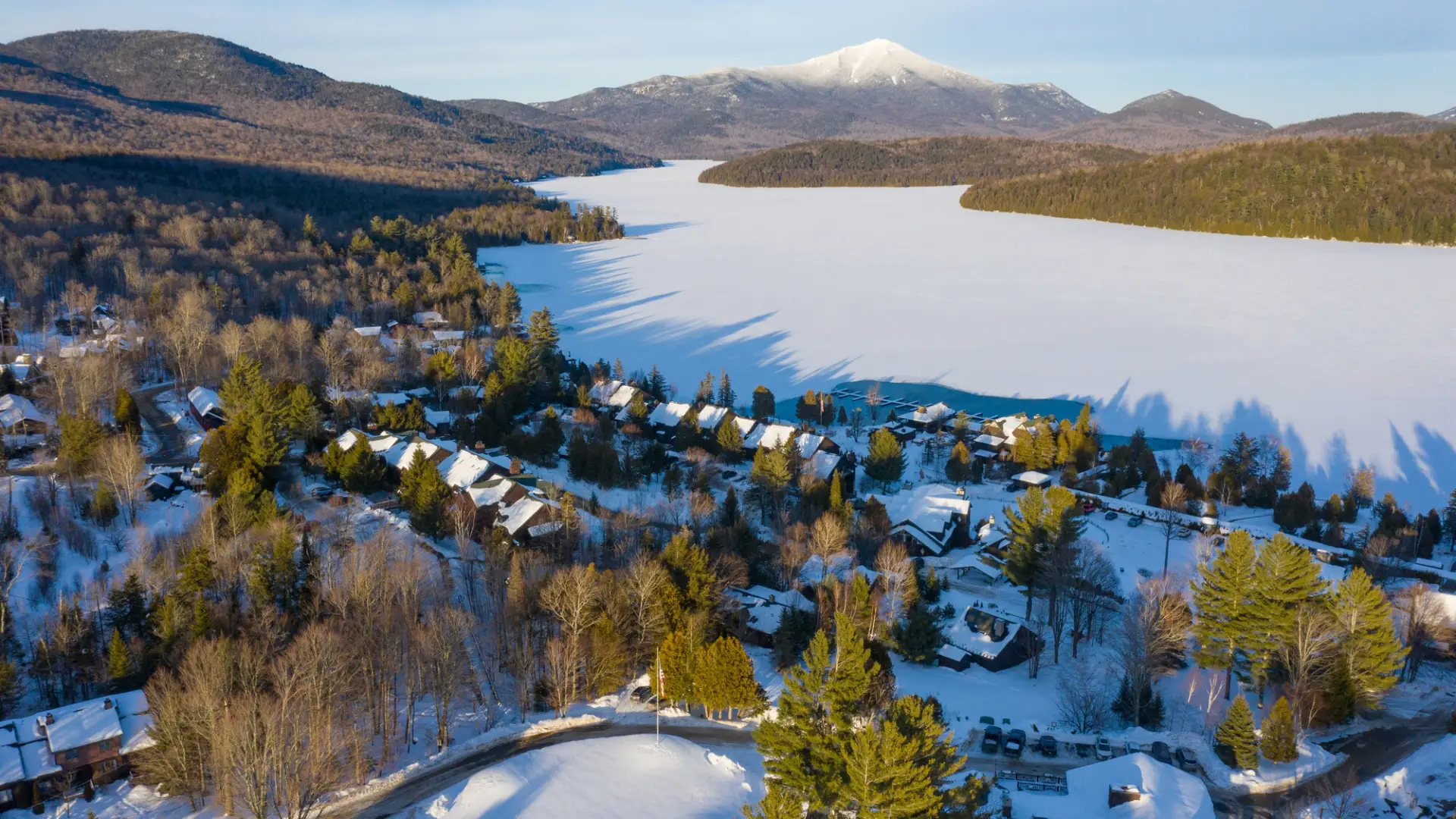 An aerial view of Lake Placid in winter with Whiteface Mountain in the background